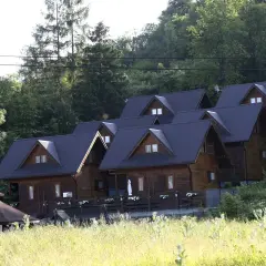 Drewniane domki w górach, idealne miejsce, gdzie szukać noclegu. Otoczone zielenią, z widokiem na las.