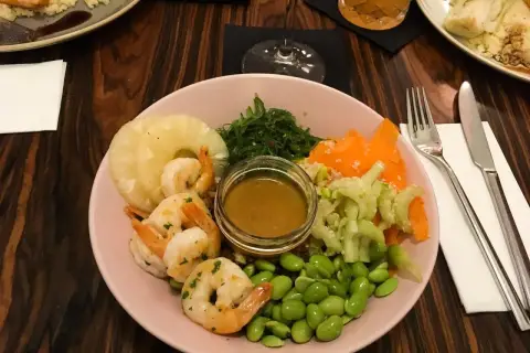 Kolorowa miska z krewetkami, ananasem, edamame i sosem. Idealne miejsce, gdzie zjeść w Krakowie.