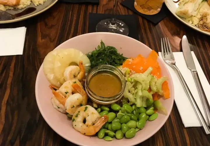 Kolorowa miska z krewetkami, ananasem, edamame i sosem. Idealne miejsce, gdzie zjeść w Krakowie.