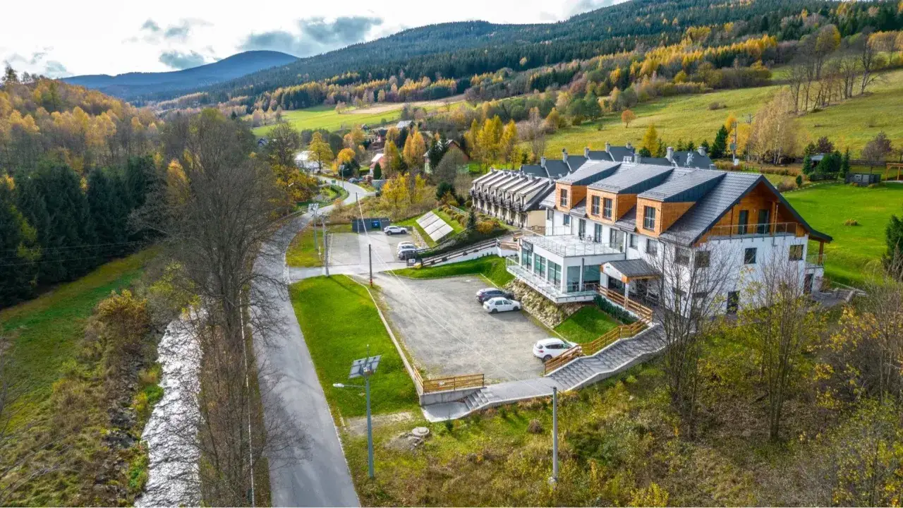 Piękny hotel w górach, idealne miejsce, gdzie szukać noclegu na jesienny wypoczynek. Otoczony kolorowymi drzewami i zielonymi wzgórzami.